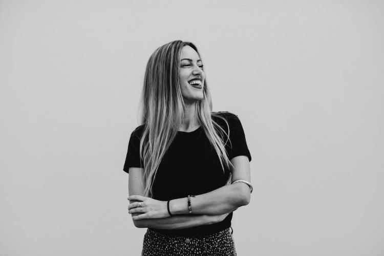 Mz Lopez wearing a black shirt in a black and white image against a white background.