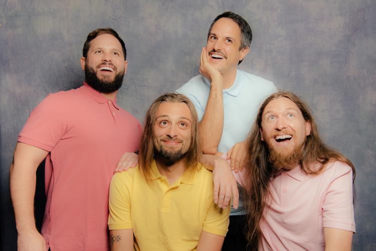 Osaka Punch in a high schoolesque photo. All members are posing cheesily with colourful shirts on against a blue grey background