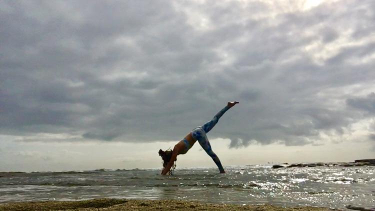 Lady in ocean doing yoga pose