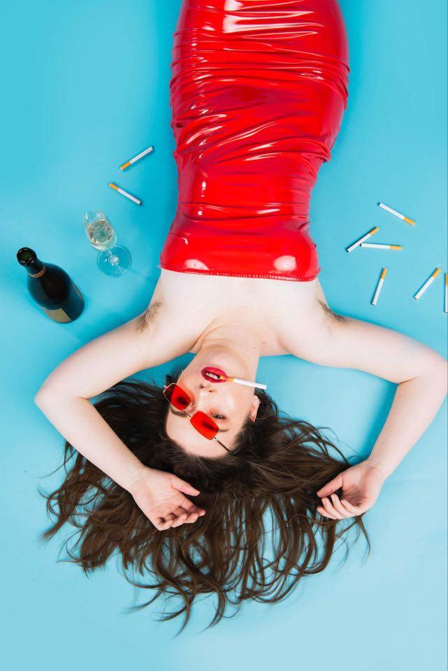 Performer Poly Lez slut laying down with cigarettes and booze around her