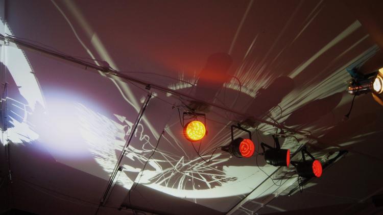 Picture of visuals projecting onto a roof of a tent with other parcan lighting on truss